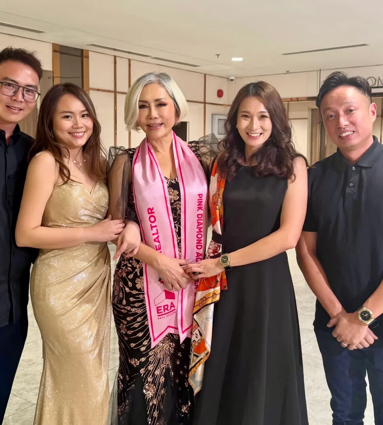 Eve Ang wearing the Pink Diamond Achiever sash with her team