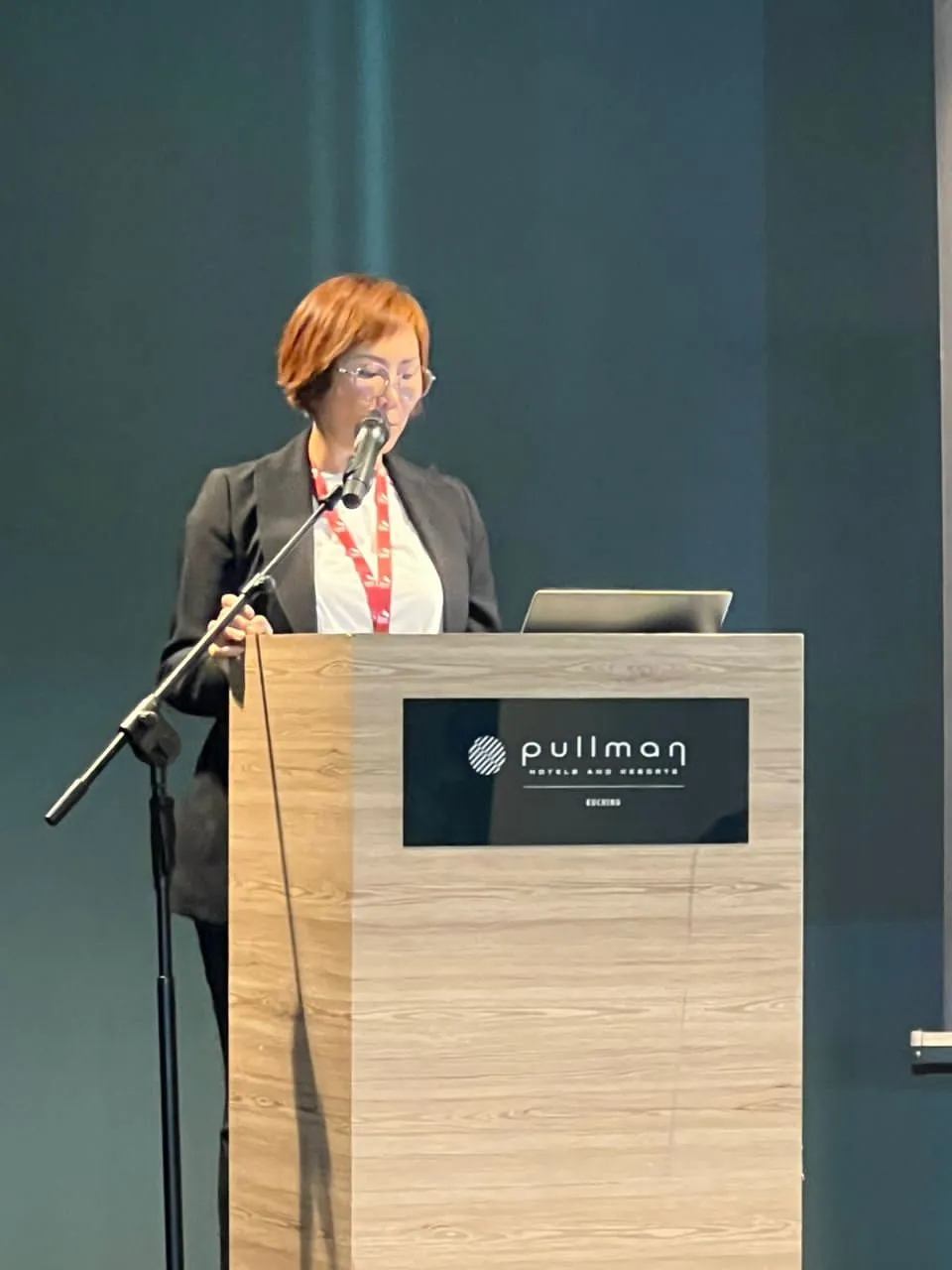 Eve Ang speaking at the podium during an industry sharing session