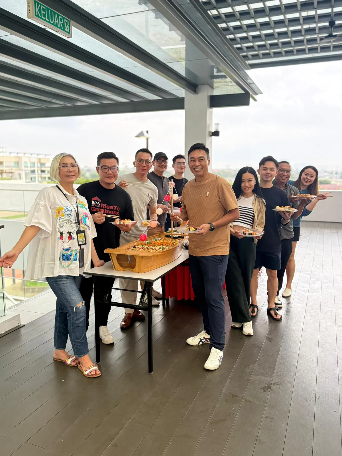 Eve Ang’s team sharing a sushi boat feast on a rooftop