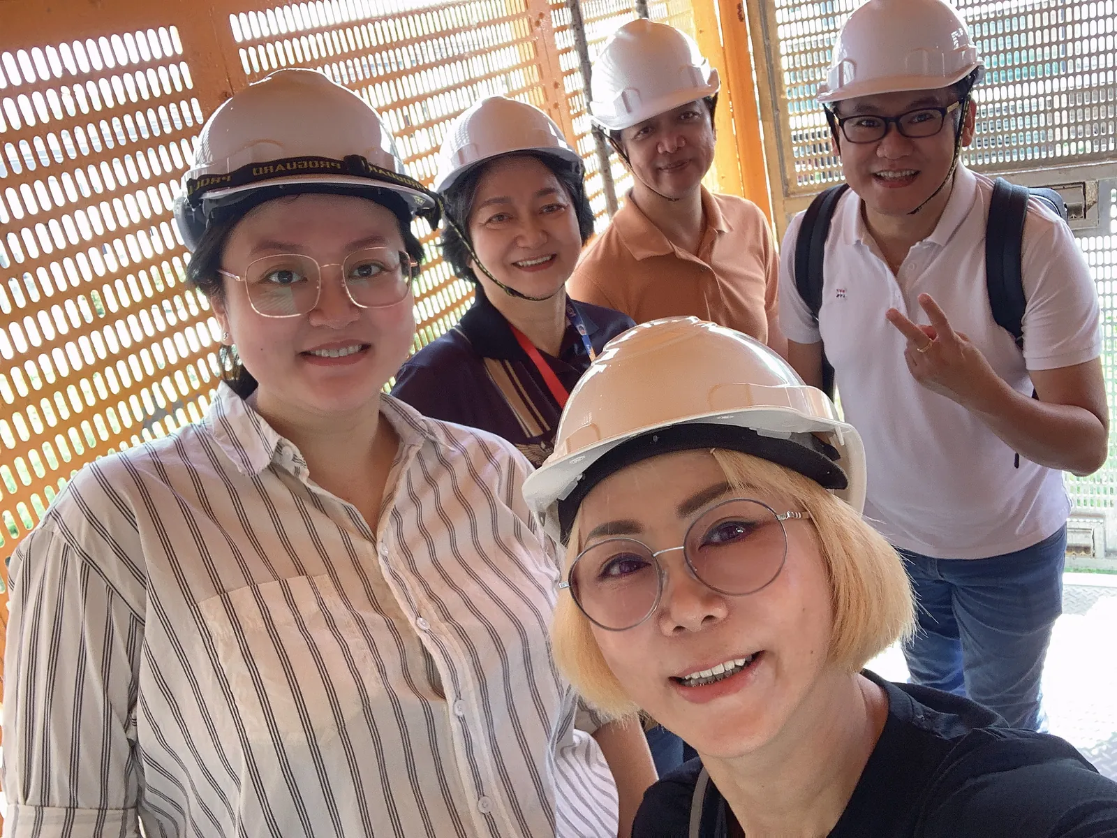 Eve Ang and her team wearing hard hats on a construction site visit